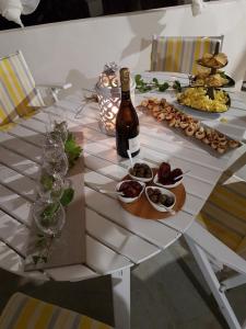 a table with a bottle of wine and plates of food at Il Dammuso di Tracino in Pantelleria