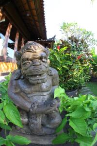 a statue of a god in a garden at Villa Gede Private Guest House in Selemadeg