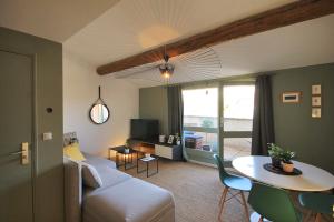 a living room with a couch and a table at Picasso - Appartement Avignon centre in Avignon