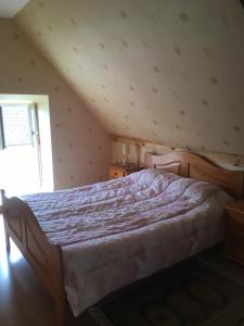 - une chambre mansardée avec un grand lit dans l'établissement Gite des Perrieres, à Saint-Pierre-le-Moûtier