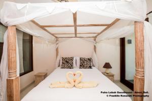 Ein Bett oder Betten in einem Zimmer der Unterkunft Putra'Lebah Amed Guest House
