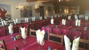 un comedor con mesas rojas y sillas con servilletas blancas en Auberge Roman, en La Javie 14 fotos más