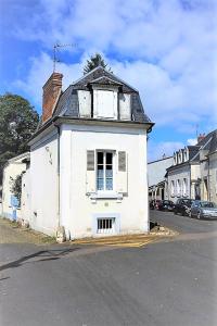 une vieille maison blanche assise sur le côté d'une rue dans l'établissement Maison, à Bourges