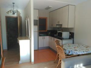een keuken met witte kasten en een tafel en stoelen bij Bravo 24 in Fuengirola