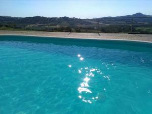 ein großer Pool mit blauem Wasser und Bergen im Hintergrund in der Unterkunft Ca Dell'Aglio in Momperone