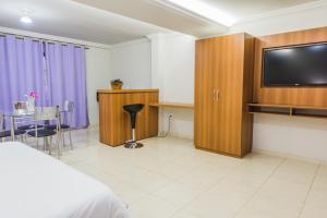 um quarto de hotel com uma cama e uma televisão de ecrã plano em Solar Hotel em Lagoa da Prata