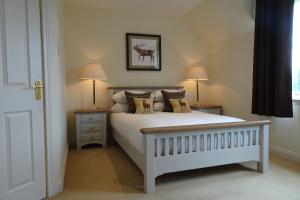 
a bedroom with a bed and a dresser at Loch Ness Lodge in Drumnadrochit

