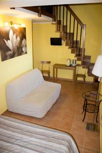 ein Wohnzimmer mit einem Bett und einer Treppe in der Unterkunft Agriturismo Ai Guiet in Superga