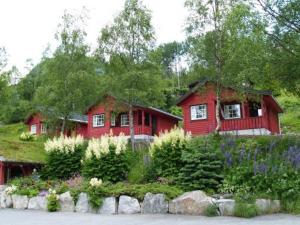 a red house with a garden in front of it at Røldal Hyttegrend & Camping in Røldal