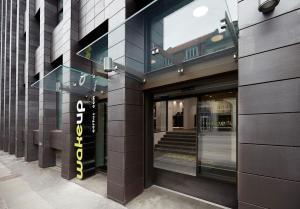 a store front with a sign on the side of a building at Wakeup - Aarhus in Aarhus
