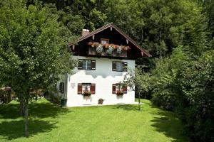 a white house with flower boxes on the roof at Ferienwohnungen am Märchenpark in Marquartstein