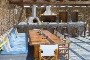 a wooden table and chairs in a kitchen with a stove at Elia Sea View Luxury Villa in Elia Beach