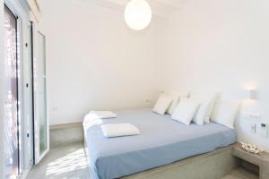 a white bedroom with a blue bed with white pillows at Elia Sea View Luxury Villa in Elia Beach +24 photos