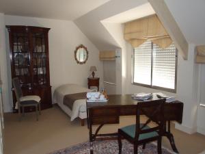 a bedroom with a desk and a bed and a desk and chair at il giardino F Heudier ,E Decourcy ,Tessy sur vire Manche in Tessy-sur-Vire