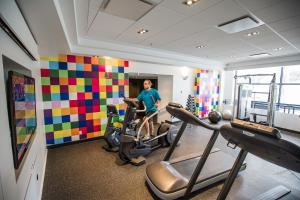 een man in een kamer met een fitnessruimte bij Hôtel Alt Québec in Québec