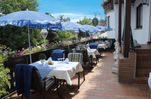 una fila de mesas con sombrillas azules en un restaurante en Gasthof zur Sonne Winzenhohl en Hösbach