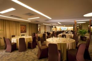 a conference room with tables and chairs and tablesktop at Grand Tropic Suites Hotel in Jakarta