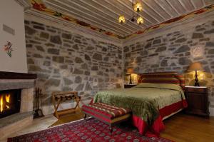 a bedroom with a bed and a stone wall at Emotions Country Resort in Voútiron