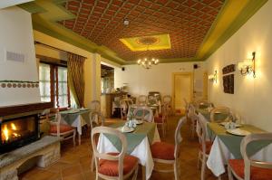 a restaurant with tables and chairs and a fireplace at Emotions Country Resort in Voútiron
