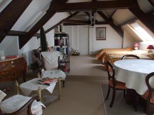 una camera con letto, tavolo e sedie di il giardino F Heudier ,E Decourcy ,Tessy sur vire Manche a Tessy-sur-Vire