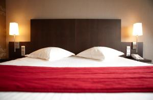 a bedroom with a large bed with two pillows at Biznis Hotel in Lokeren