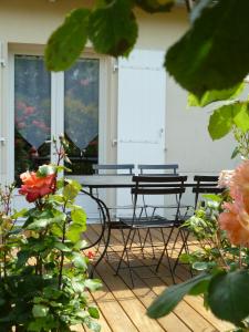 un patio con 2 sillas, una mesa y 2 ventanas en Guzzo, en Châtelaillon-Plage