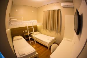 a small room with two bunk beds and a television at Hotel Esplanada in Campinas
