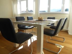 uma mesa branca com cadeiras pretas à volta em Quartier 1 em Friburgo em Brisgóvia