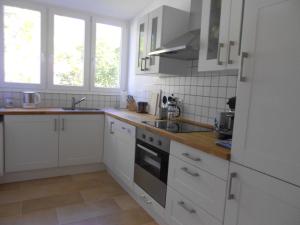 uma cozinha com armários brancos e um forno com placa de fogão em Quartier 1 em Friburgo em Brisgóvia