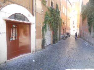 ローマにあるIn the heart of Trastevereの石畳の道を犬歩く者
