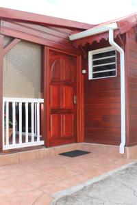 a house with a red door and a balcony at Gites Les Sandragons in Saint-Claude