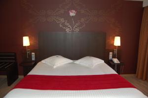 a bedroom with a large bed with two pillows on it at Biznis Hotel in Lokeren