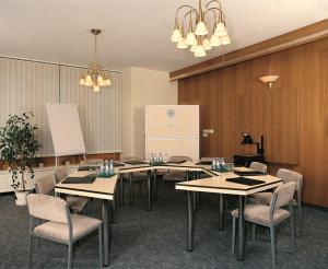 a conference room with tables and chairs and a white refrigerator at Hotel Zum Kanzler in Stolberg
