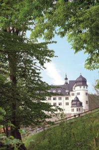 un castillo en la cima de una colina con árboles en Hotel Zum Kanzler, en Stolberg im Harz