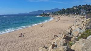 a group of people on a beach near the ocean at Residence ACQUA LINDA Porticcio in Porticcio