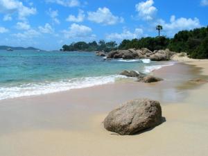 a rock sitting on a beach near the ocean at Residence ACQUA LINDA Porticcio in Porticcio