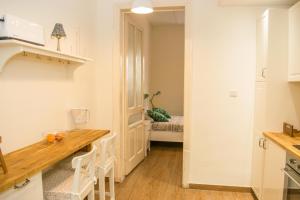 a kitchen with a wooden table and white cabinets at Vincenti Strait Street Suite in Valletta +20 photos