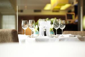 a table with wine glasses on top of it at Biznis Hotel in Lokeren