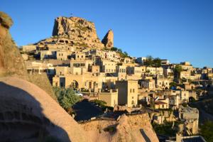 a village on top of a mountain at Helike Cave Suites in Uchisar
