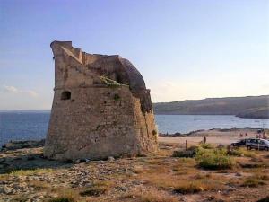 an old building sitting on the beach next to the water at La Casetta in Poggiardo +16 photos