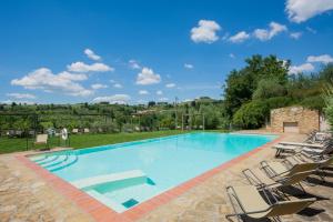 een groot zwembad met ligstoelen eromheen bij Borgo Bottaia in Grassina