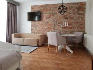 a living room with a couch and a table with chairs at Alfa Studio in Sibiu
