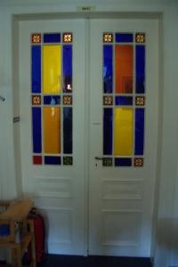 two doors with stained glass windows in a room at Gästehaus Verhoeven in Goslar