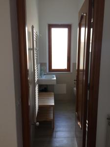 uma casa de banho com um lavatório, um WC e uma janela. em Villa Maria em Giardini Naxos