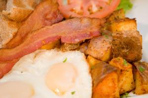 a plate of breakfast food with an egg and bacon at The Rex Hotel Jazz & Blues Bar in Toronto