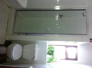 a bathroom with a mirror and a sink and a window at Aberdeen Guest House in Ilford