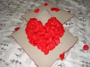 una torta con fiori rossi sopra un letto di Le Petit Etang a La Trinité-Surzur