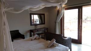 a bedroom with two beds and a large window at Beautiful Mountain Views From A 2-Bedroom Home With Pool in Hoedspruit