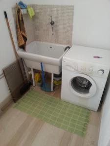 a bathroom with a sink and a washing machine at Casette nel Borgo in Borgagne