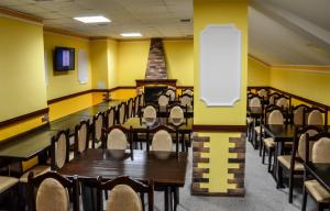 comedor con mesas y sillas y paredes amarillas en Hotel Obolon-Arena en Kiev